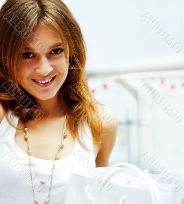 Photo of young joyful woman with shopping bags on the background