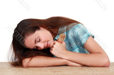 woman sleeping on a table and holding a paint brush