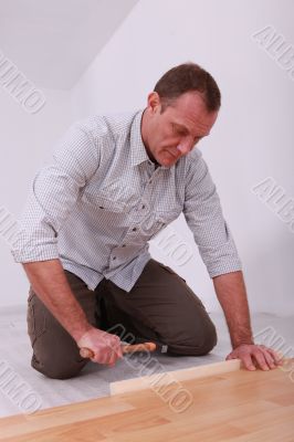 handyman laying  a laminate parquet