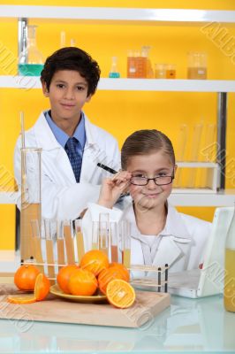 Children doing chemistry experiments with orange juice Children doing chemistry experiments with orange juice