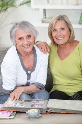 duo of mature women skimming through album