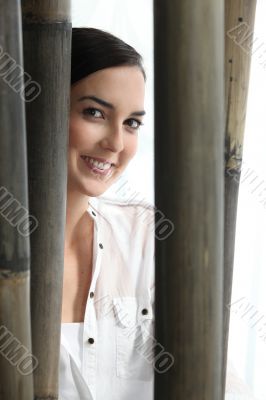 Woman stood behind bamboo poles Woman stood behind bamboo poles