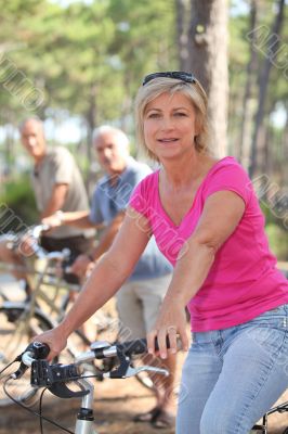 Woman riding a bike with friends in a forest Woman riding a bike with friends in a forest