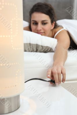 Woman switching off lamp Woman switching off lamp