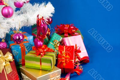 Heap of the Christmas presents under decorated white evergreen t