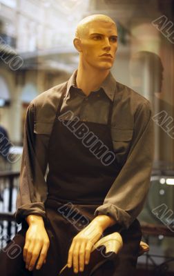 Dummy in working clothes in a show-window of a boutique