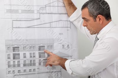 Architect examining a blueprint in detail
