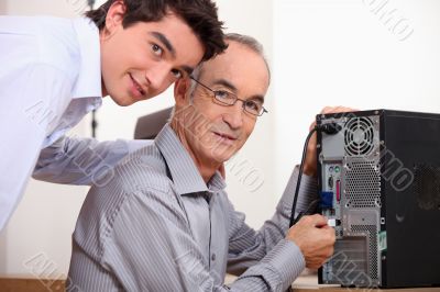 Father and son fixing a computer