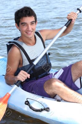 Young man paddling a kayak Young man paddling a kayak