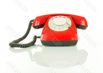 Red old fashioned telephone against white background