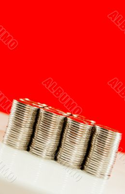 Coins stacked in bars against red background