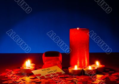 Two rings and a card with marriage proposal with six candles