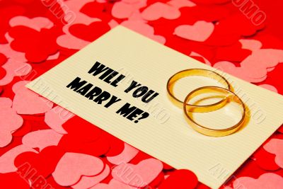 Two rings and a card with marriage proposal