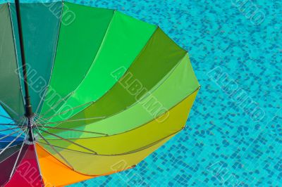 Colorful umbrella on a swimmingpool water  background