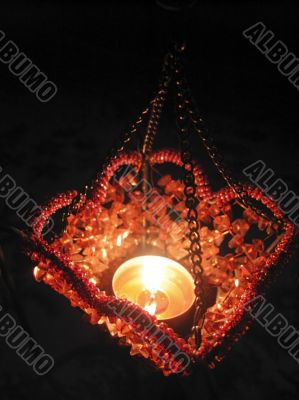 Flaming candle in basket and dark background Flaming candle in basket and dark background