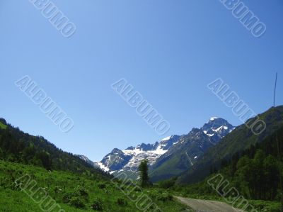 Road leads close to the snowy mountain Road leads close to the snowy mountain
