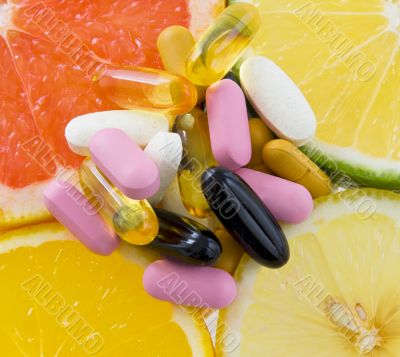 Group of pills on fruit slices ,orange, lemon, lime, grape fruit