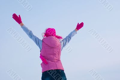 Teen girl staying with raised hands