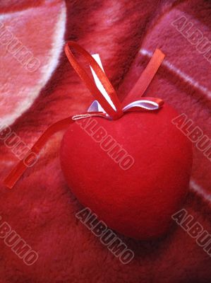Red heart with red and white stripes on the pink background Red heart with red and white stripes on the pink background