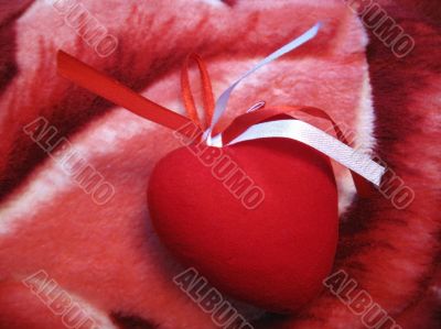 Red heart with red and white stripes on the pink background Red heart with red and white stripes on the pink background