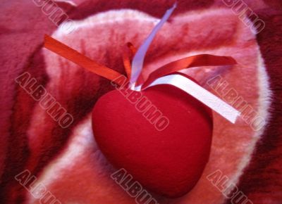 Red heart with red and white stripes on the pink background Red heart with red and white stripes on the pink background