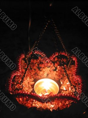 Flaming candle in basket and dark background Flaming candle in basket and dark background