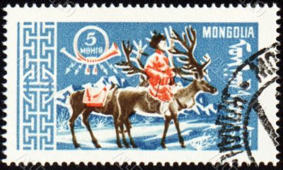 Man with reindeer in winter time on post stamp