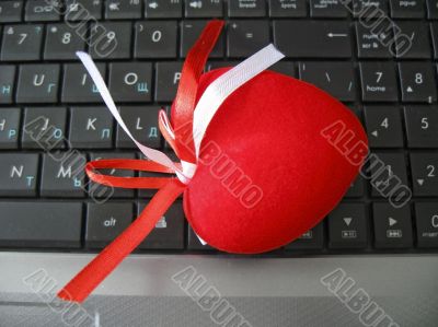 Red heart laying on the keyboard of notebook Red heart laying on the keyboard of notebook