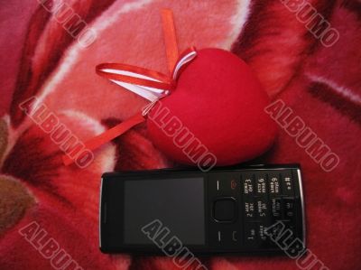 Red heart with red and white stripes and mobile phone Red heart with red and white stripes and mobile phone