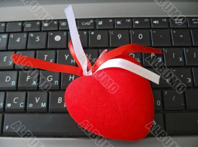 Red heart laying on the keyboard of notebook Red heart laying on the keyboard of notebook