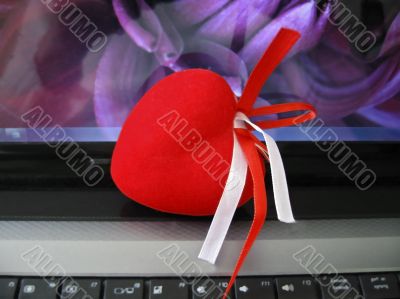 Red heart laying on the keyboard of notebook Red heart laying on the keyboard of notebook