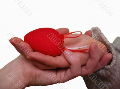 Woman hand hold a Valentine heart with a help of mans hand