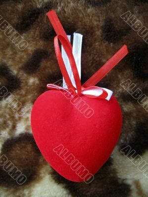 Red heart with red and white stripes on the brown background