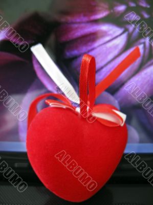 Red heart laying on the keyboard of notebook Red heart laying on the keyboard of notebook
