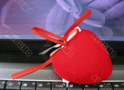Red heart laying on the keyboard of notebook Red heart laying on the keyboard of notebook