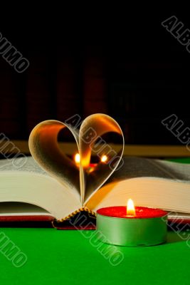 Open book with burning candle