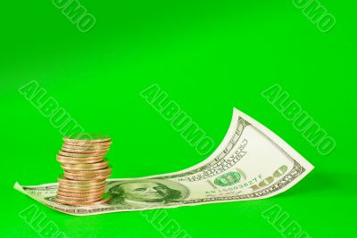 Coins stacked in bars laying on stack of 100 dollar bill