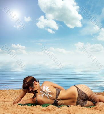on the beach with suntan lotion on her back on the beach with suntan lotion on her back
