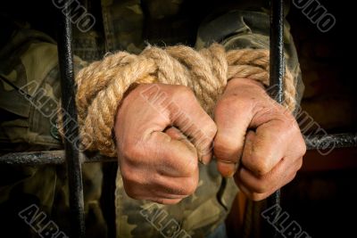 Man with hands tied up with rope