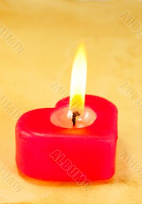 Burning heart shaped candle
