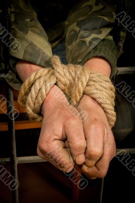 Man with hands tied up with rope