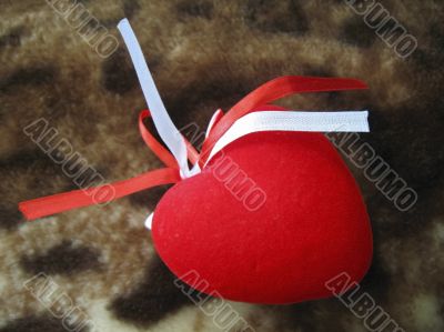 Red heart with red and white stripes on the brown background Red heart with red and white stripes on the brown background