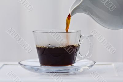 Pouring coffee into a half full cup