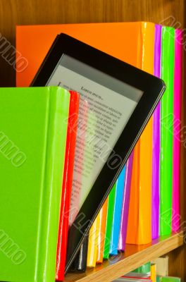 Row of colorful books and electronic book reader