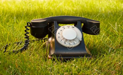 Retro styled rotary telephone on grass