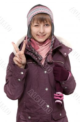 Young beautiful girl in winter to jacket and hat shows Ok