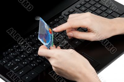 Feminine hands with bank card on keyboard