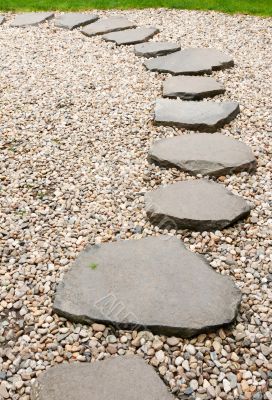 Path from stone with green herb