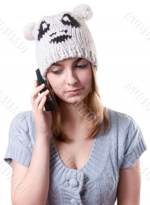 Beautiful girl in winter hat with telephone