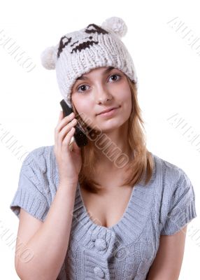 Beautiful girl in winter hat with telephone